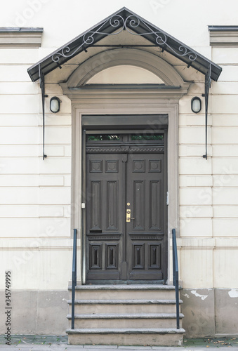 Old closed wooden doors, decorative outdoor entrance, front view building facade © BOOCYS