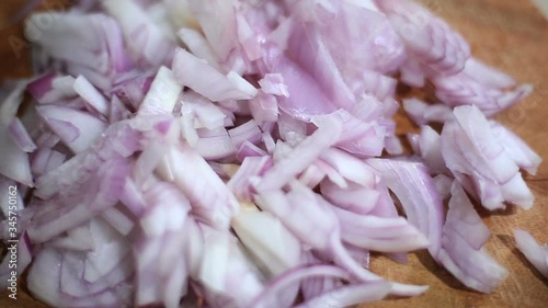 blurry shallow focus close view of small onion pieces or slices on wood.