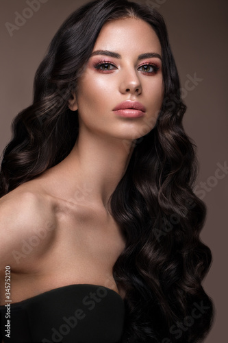 Beautiful brunette model: curls, classic makeup and full lips. The beauty face.