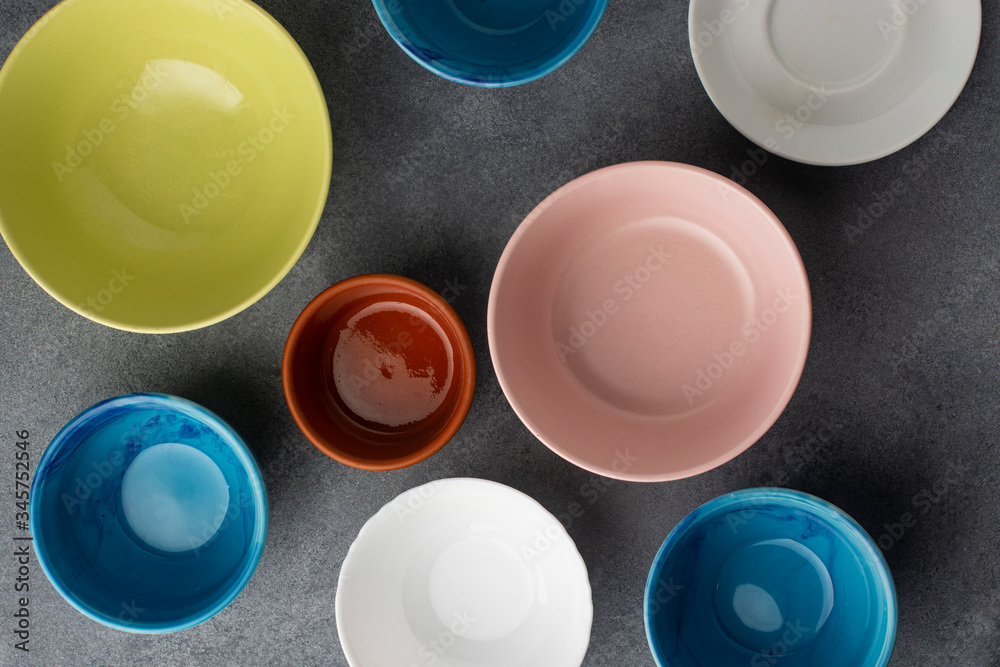 Several empty ceramic bowls on a gray background. View from above. Several empty ceramic bowls on a gray background. View from above.