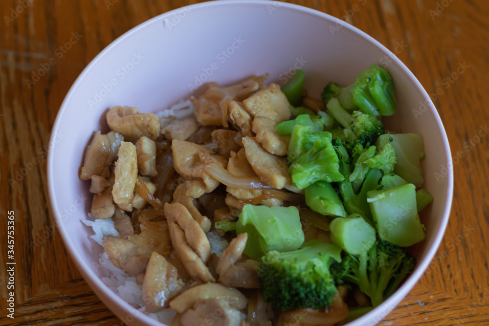 Cooked teriyaki chicken, steamed rice and broccoli in a pink bowl. Cooked teriyaki chicken, steamed rice and broccoli in a pink bowl.