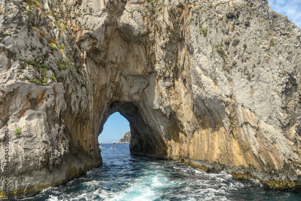 The arched tunnel in the Faraglioni rock formation off the coast of Capri.