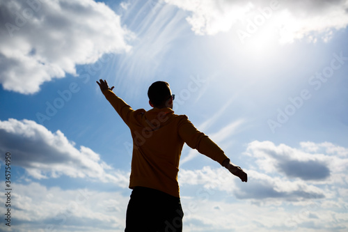 guy tourist freelancer on a background of blue sky with white clouds, bright sunny day, nature and human freedom