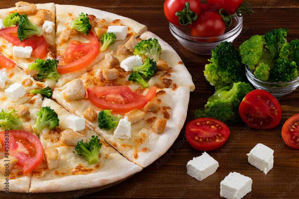 Pizza with chicken, broccoli and feta cheese on wooden background Pizza with chicken, broccoli and feta cheese on wooden background