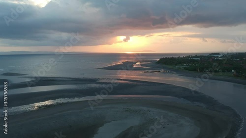 A fast drone fly off from an epic sunset appears peninsula in the harbor of Prancak Perancak Peninsula bali indonesia photo