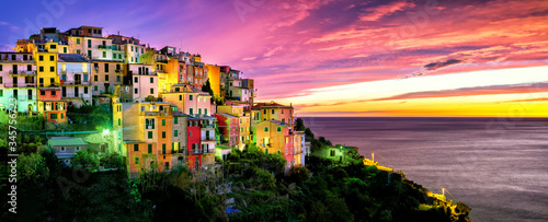 Evening panorama of the medieval town of Cornilla in the Cinque Terre National Park in November, purple sunset and colorful houses in Liguria
