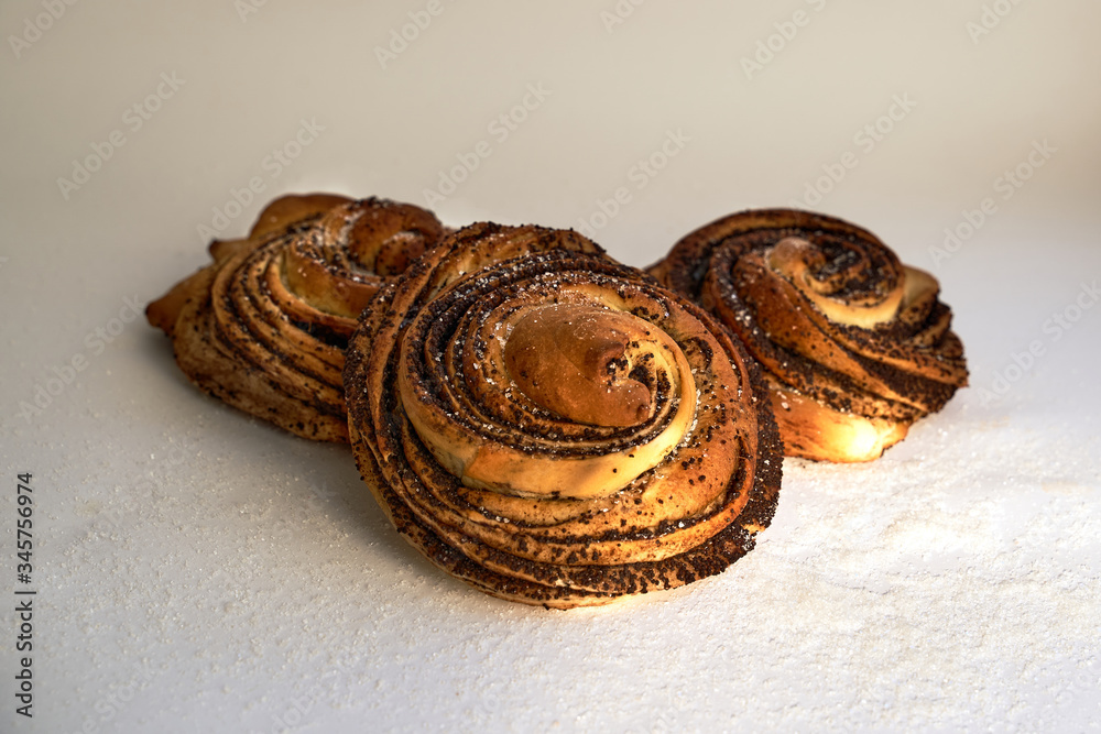 sweet baking pastry buns on a white background sprinkled with poppy seeds sweet baking pastry buns on a white background sprinkled with poppy seeds