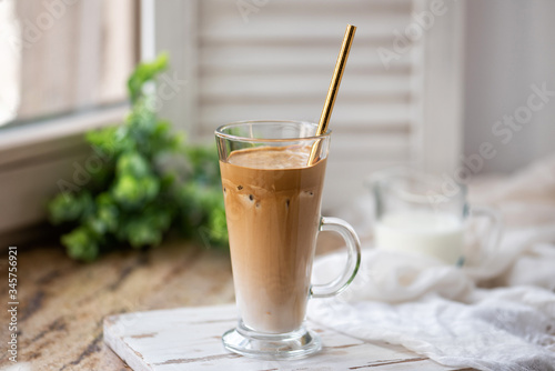 Fotografie Dalgona coffee with ice and fluffy creamy whipped instant coffee on wooden tray