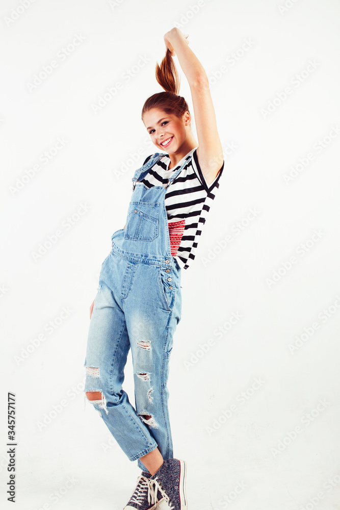 young pretty teenage hipster girl posing emotional happy smiling on white background, lifestyle people concept