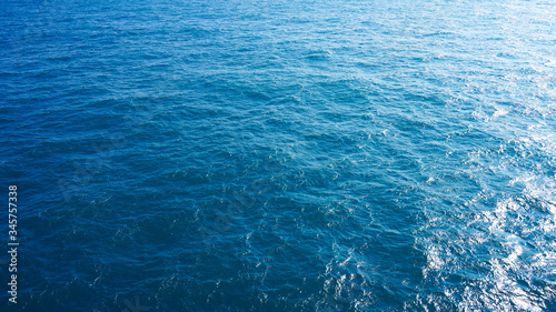 Pure turquoise blue water of the Pacific Ocean. reflection of the sun in the waves on the surface. Natural sea composition, texture, background. aerial view