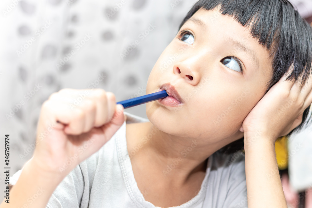 Little boy thinking about somthing and looking up, confused about an idea. Small child hand holding pencil. Little boy thinking about somthing and looking up, confused about an idea. Small child hand holding pencil.