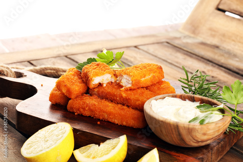 fresh fish fingers with remoulade sauce. breaded fish fingers with lemon and remoulade photo