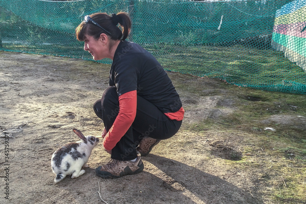 Woman gives food to rabbit. Nature love and vegan concept