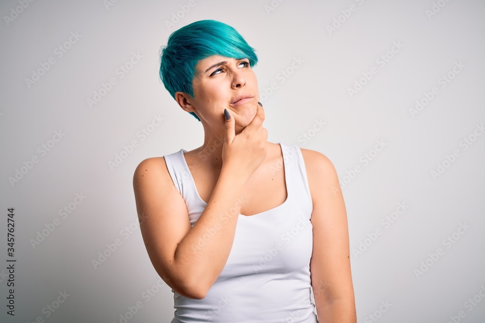 Young beautiful woman with blue fashion hair wearing casual t-shirt over white background Thinking worried about a question, concerned and nervous with hand on chin Young beautiful woman with blue fashion hair wearing casual t-shirt over white background Thinking worried about a question, concerned and nervous with hand on chin