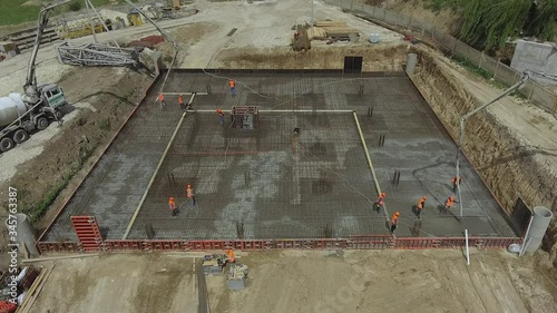 Group of builders poured concrete. The foundation of a large construction site, the builders are building a skyscraper or factory. Workers working at a construction site.