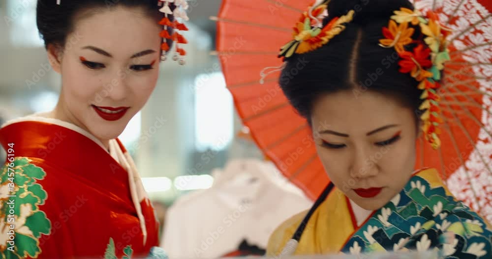 Attractive japanese geishas in traditional dresses walking around modern city, talking and positively smiling - traditional culture in modern world 4k footage Attractive japanese geishas in traditional dresses walking around modern city, talking and positively smiling - traditional culture in modern world 4k footage