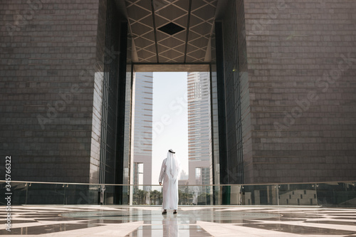 Emirates urban lifestyle in the big city with Arab guy investor checking out the city in gulf country. Photography of Arabian places and building construction.