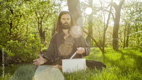 A qigong master conducts meditation using a gong and Crystal bowl, Crystal Tibetian singing bowl, a master meditates receives energy for the body photo