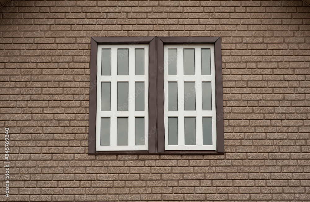 brown brick wall with a white window in the middle
brown brick wall with a white window in the middle
