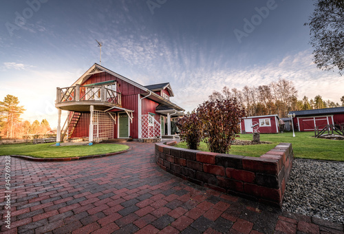 Fotografia Beautiful traditional scandinavian wooden villa at countryside, evening after ra