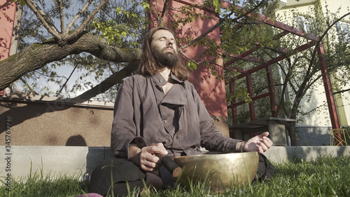 A qigong master conducts meditation using a gong and Crystal bowl, Crystal Tibetian singing bowl, a master meditates receives energy for the body photo