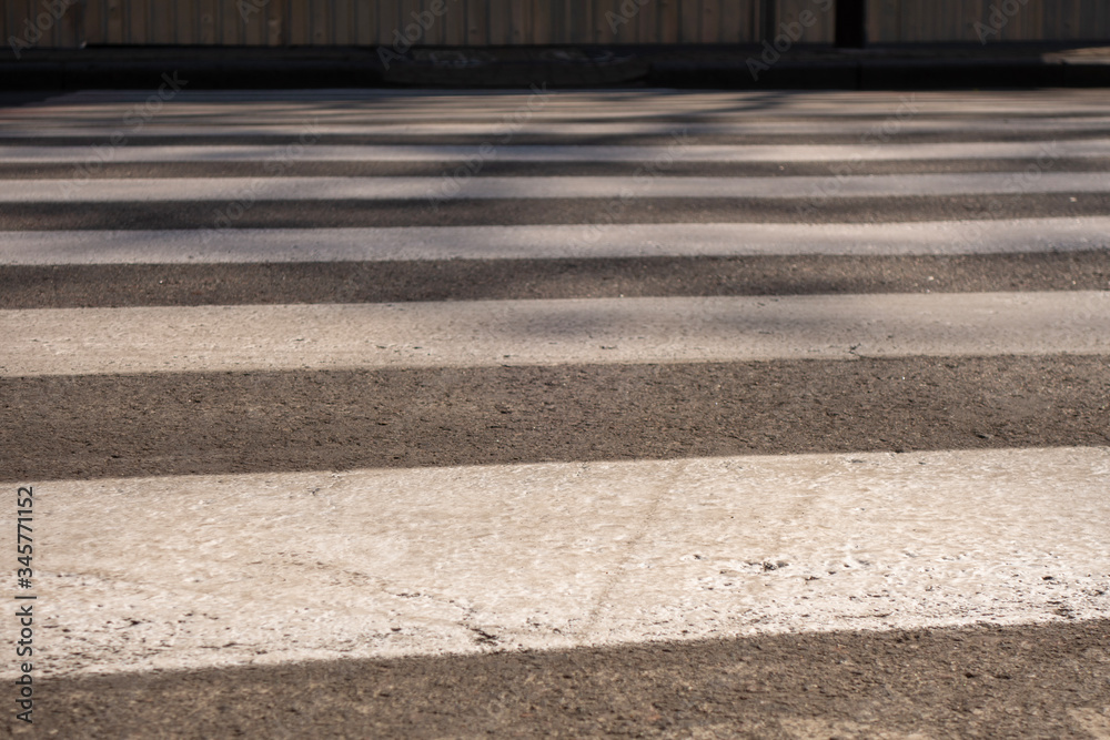 Close-up of a gray and white pedestrian crossing markings.