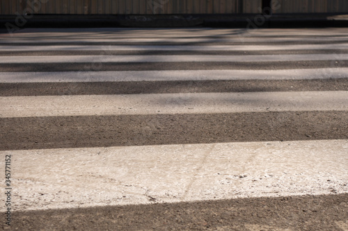 Close-up of a gray and white pedestrian crossing markings.