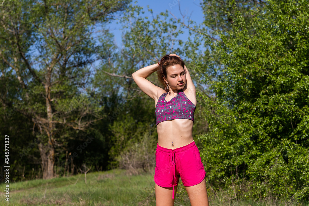 Girl in sport clothes doing sport exercises on fresh air