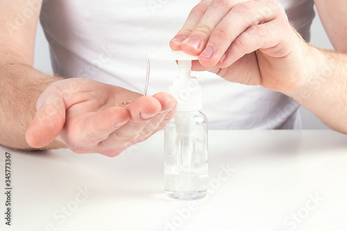 Man person using small portable antibacterial hand sanitizer on hands.