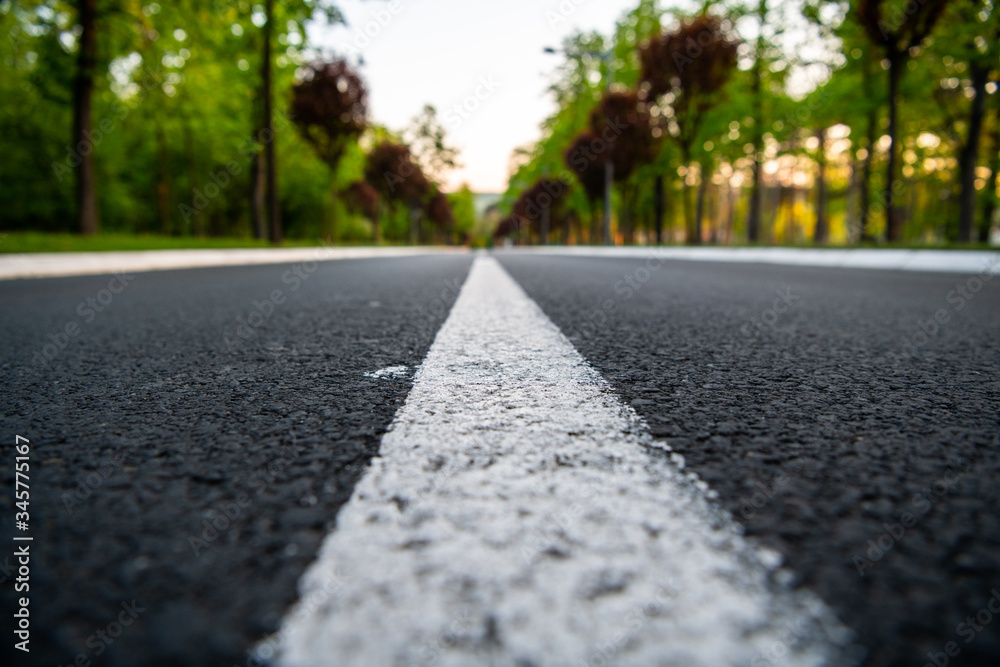 Black asphalt road and white dividing lines