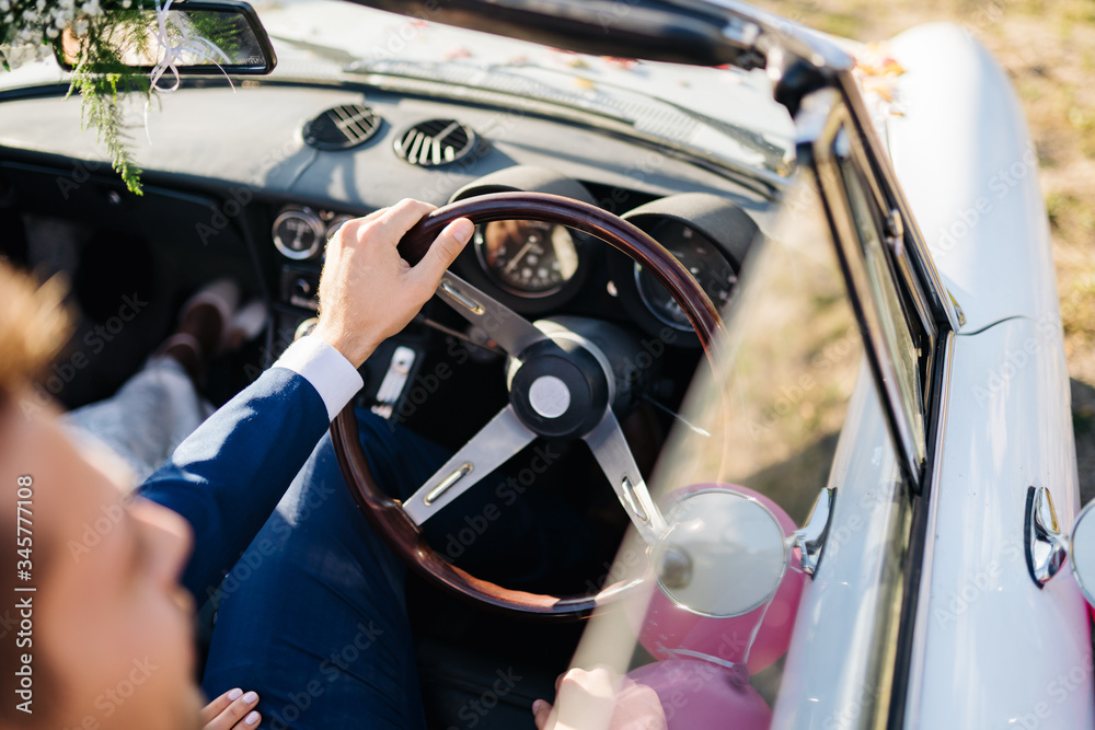 photo of a groom driving a wedding car