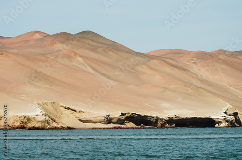 Paisaje desértico costero en Paracas, Peru, con dunas de arena cerca del mar 