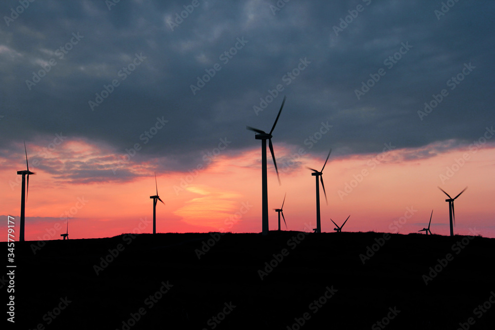 Turbines on a hill with a sunset background Turbines on a hill with a sunset background