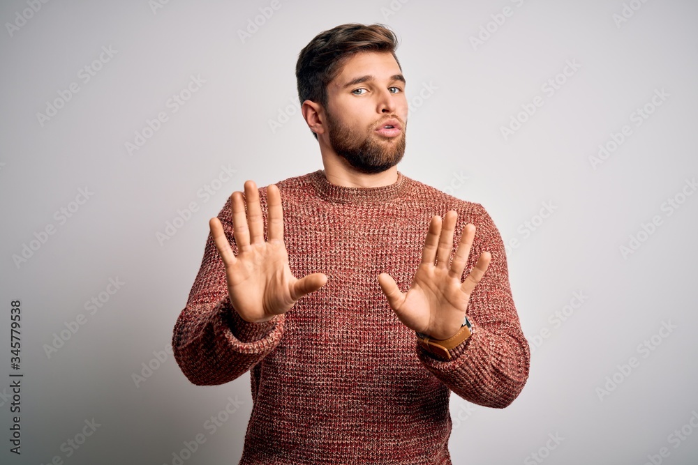 Young blond man with beard and blue eyes wearing casual sweater over ...