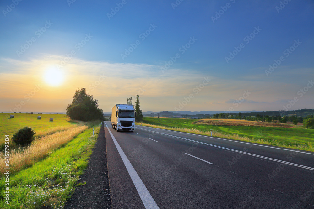 White truck transport on the road at sunset and cargo White truck transport on the road at sunset and cargo