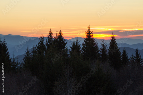 Trees and silhouettes of mountains and in a sunrise with scenic view