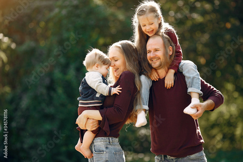 Family in a autumn park. Woman in a red sweater. Cute childrens with parents