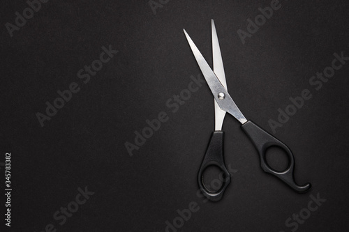 scissor hairdressing tool over black background with copy space. view from above. studio shot.