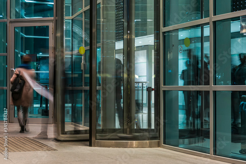  The flow of people passing through the rotating door of the modern office building ,