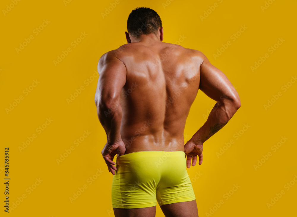Sexy male back. The back view of torso of attractive male body builder on  yellow background. Rear view of a bare-chested muscular young man in sexy  panties underwear. Stock Photo | Adobe