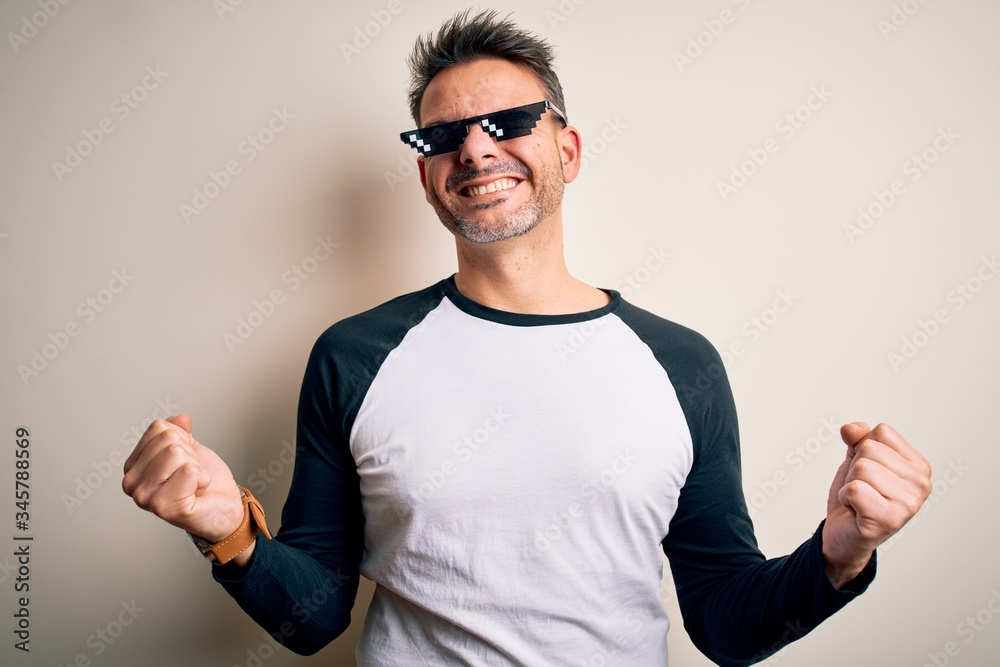 Young handsome man wearing funny thug life sunglasses meme over white  background very happy and excited doing winner gesture with arms raised,  smiling and screaming for success. Celebration concept. Stock Photo |