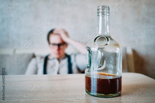 A man in a drunk shirt suffers from a headache due to the stress of being fired at work.