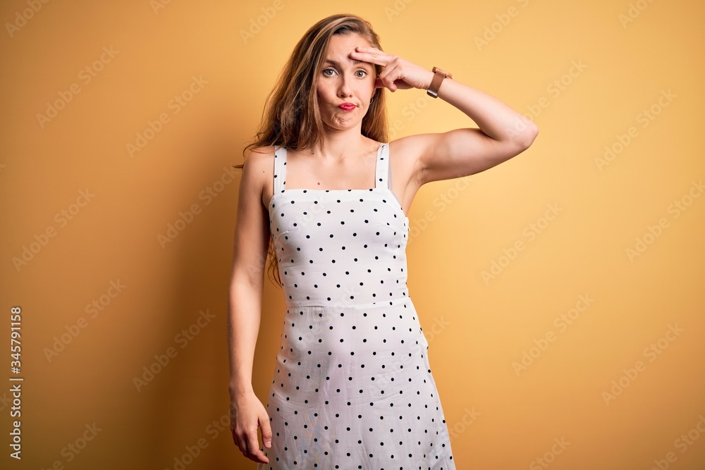 Young beautiful blonde woman on vacation wearing summer dress over yellow background worried and stressed about a problem with hand on forehead, nervous and anxious for crisis Young beautiful blonde woman on vacation wearing summer dress over yellow background worried and stressed about a problem with hand on forehead, nervous and anxious for crisis