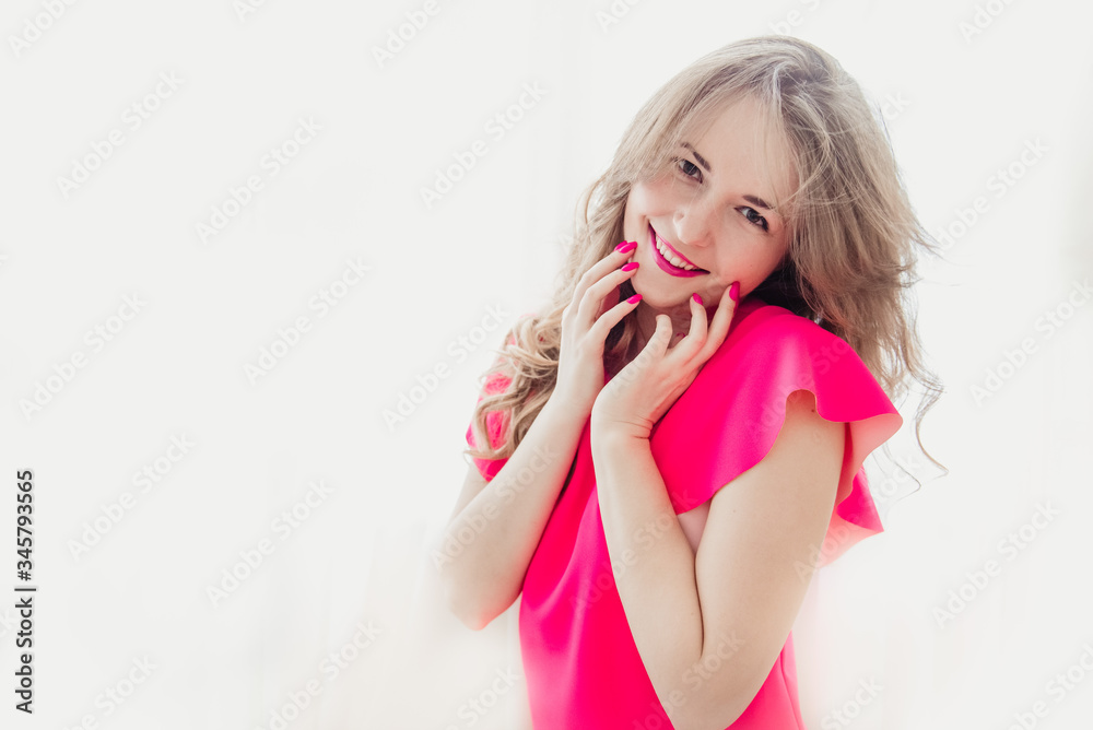 Fototapeta premium A girl in a pink blouse on a white background with pink lips and nails
