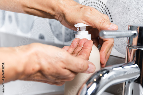 Person washing their hands with soap and hot water in the home sink wash. Cleaning the hygiene of the hand to prevent outbreaks of coronavirus.