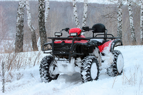 Snow covered ATV in winter forest