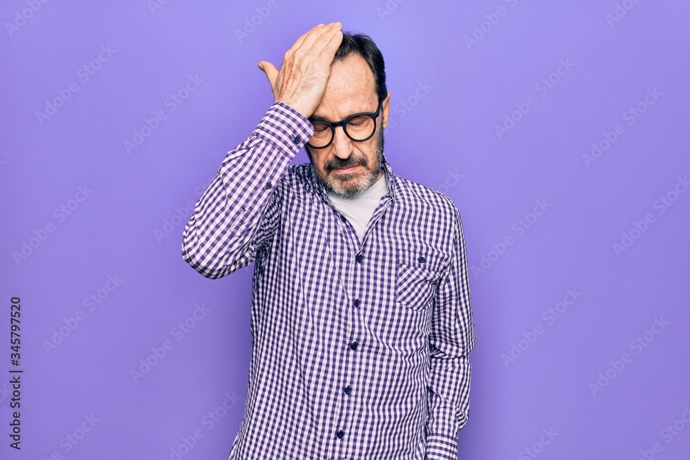 Obraz premium Middle age handsome man wearing casual shirt and glasses over isolated white background surprised with hand on head for mistake, remember error. Forgot, bad memory concept.