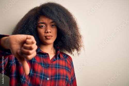 Young beautiful african american woman wearing casual shirt over isolated background looking unhappy and angry showing rejection and negative with thumbs down gesture. Bad expression. © Krakenimages.com