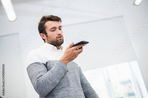 A portrait of a young businessman talking to someone using the s