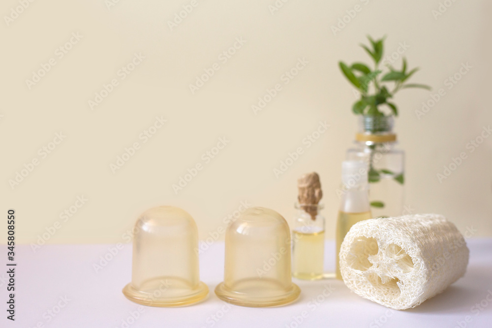 Silicone jars, loofah sponge and massage oil. Aaccessories for anti-cellulite and lymphatic body massage